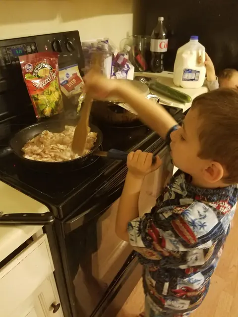 Chef Joe’s son stirring a pot at the stove