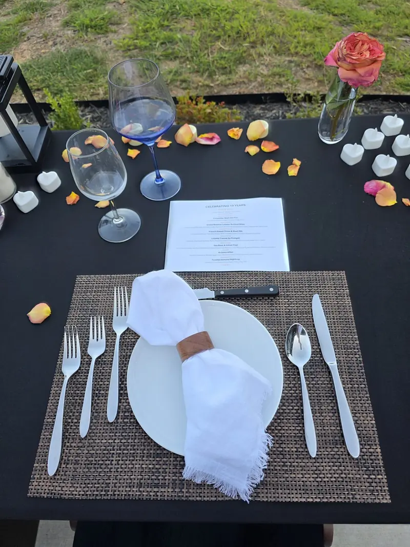 Place setting with folded napkin, glassware and printed menu