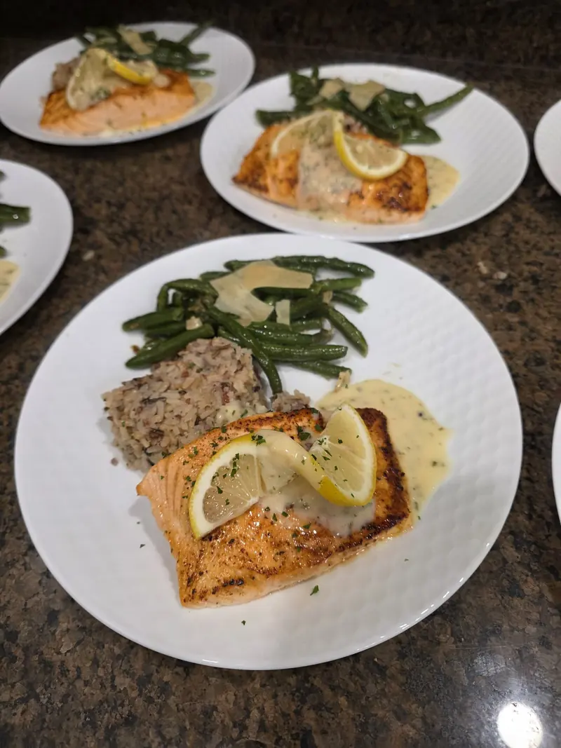 Lemon herb salmon and chicken plated with wild rice and green beans