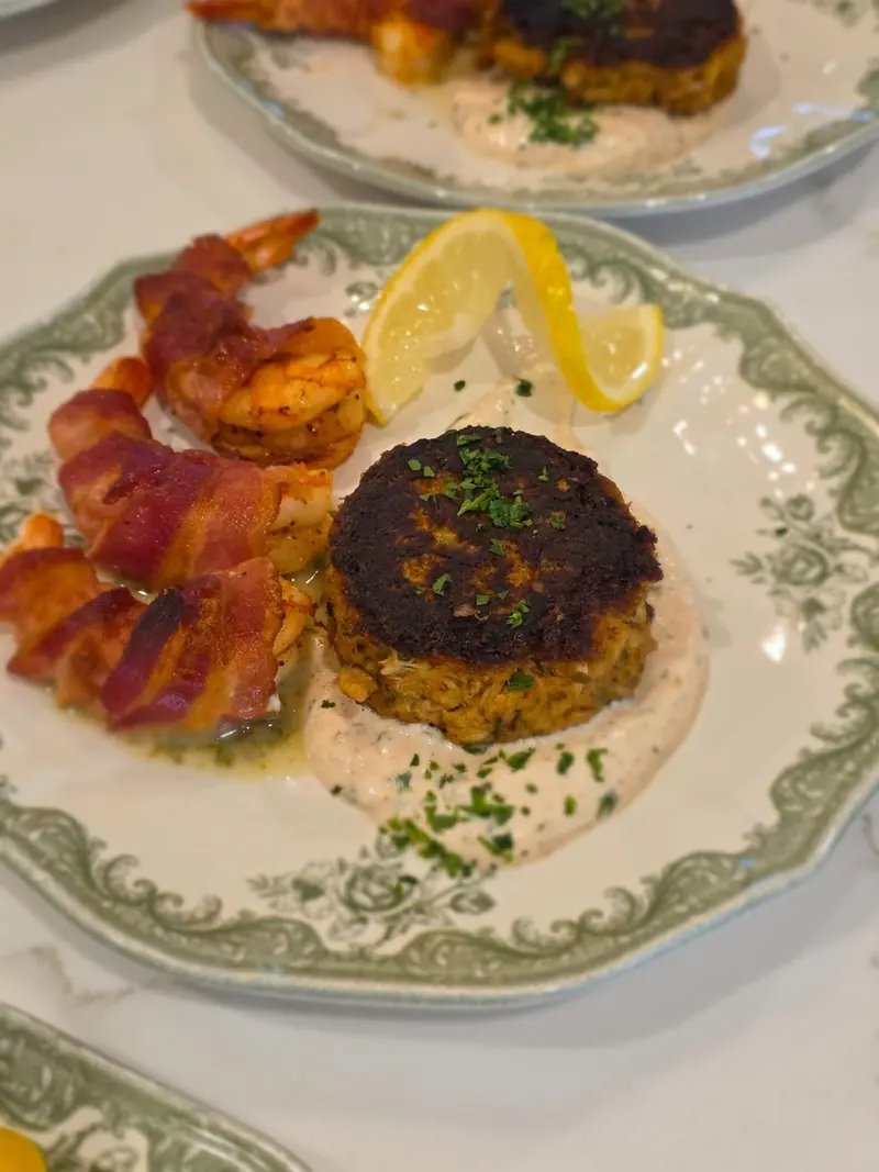 Stuffed shrimp and crab cake plated on fine china