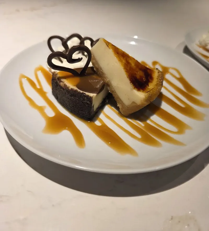 Plated dessert with a chocolate lattice garnish and caramel swirls on a white plate