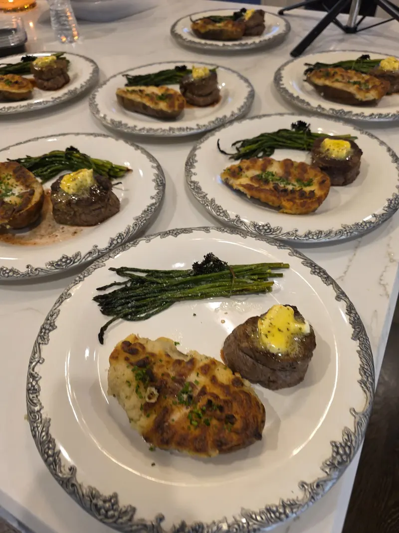 Filet mignon plates with twice-baked potatoes and asparagus lined up for service