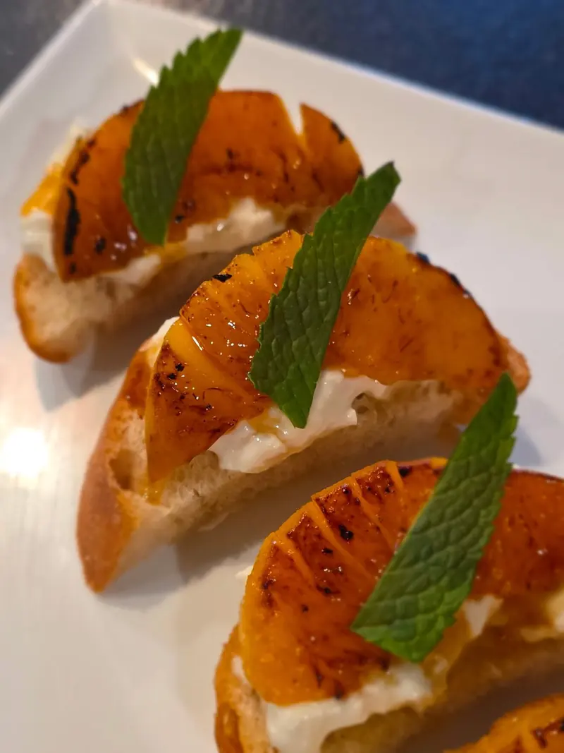 Seared peach crostini with whipped ricotta, fresh mint and hot honey